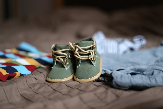 Baby shoes and clothes on a blanket