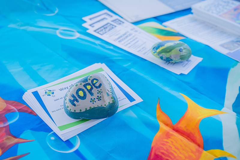 Flyers held down by a rock with the word "Hope" painted on it