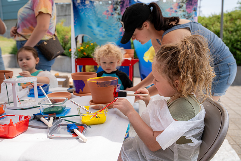 Children painting flower pots at an event